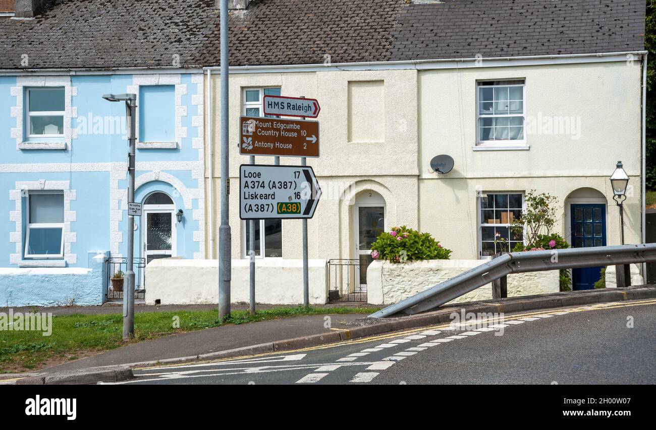 Torpoint, Cornwall, England, UK. 2021. Terraced houses, safety barrier and road signs for desinations in Cornwall, UK Stock Photo