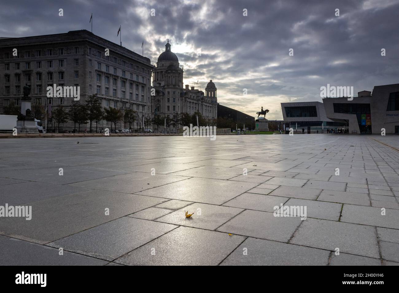 Liverpool, UK: Pier Head waterfront buildings and pedestrianised area at sunrise. Stock Photo