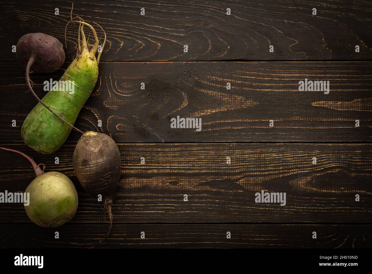 Root vegetables on a wooden background, different types of radish with