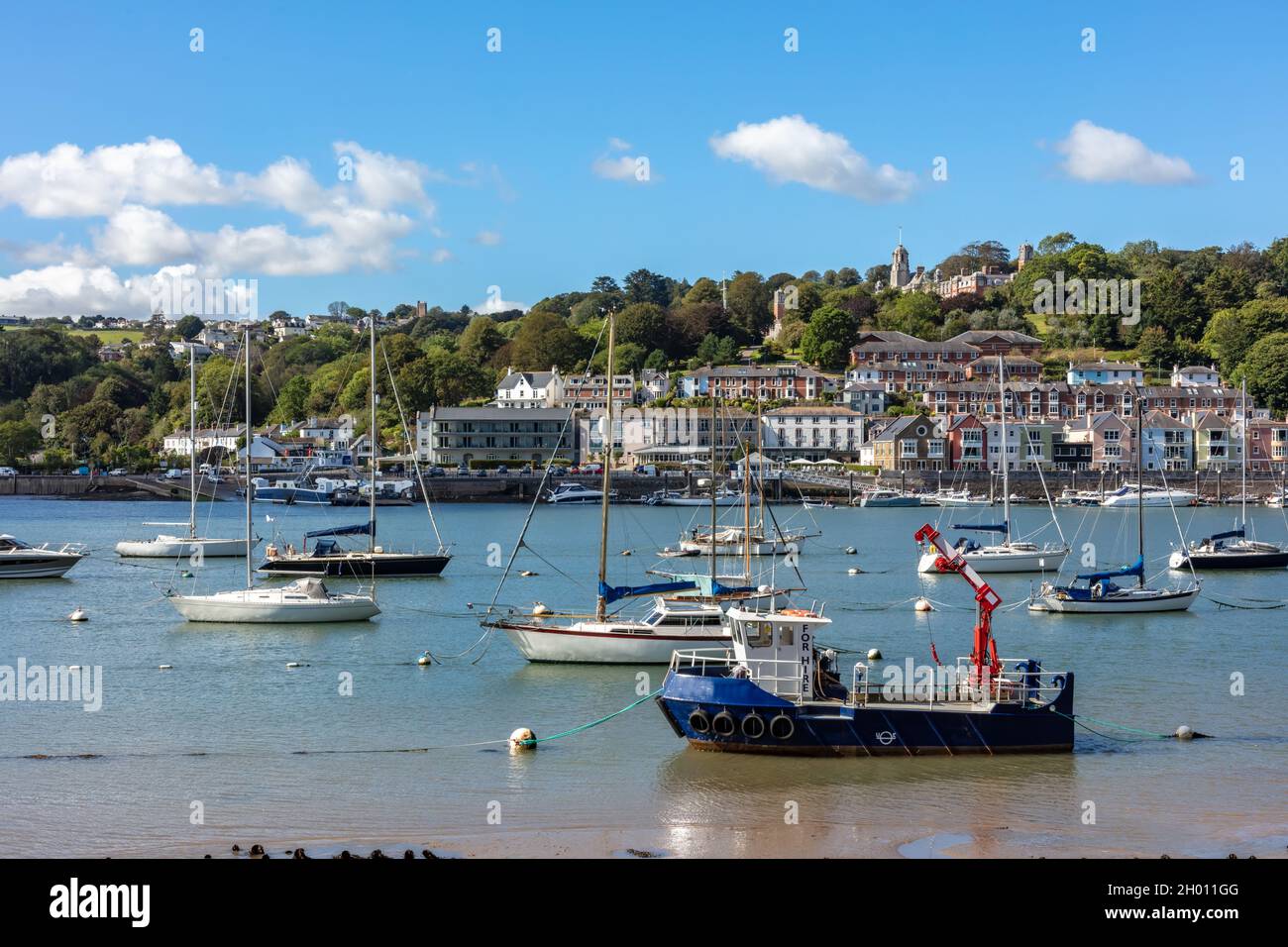 Ships moored in Dartmouth harbour with Britannia Royal Naval College in the background, South Devon, England, United Kingdom Stock Photo