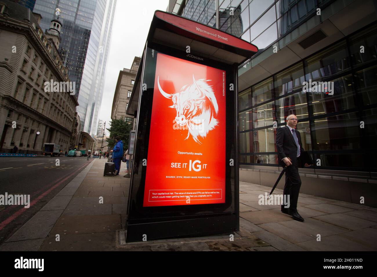 Outdoor advertising screen at bus stop advert shown is IG Group is an online trading provider Stock Photo