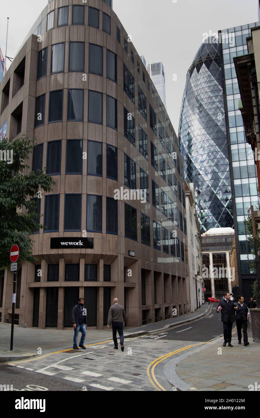 Wework, we work, American commercial real estate company that provides  shared workspaces for startups in central London with the Gherkin Swiss Re building in background Stock Photo