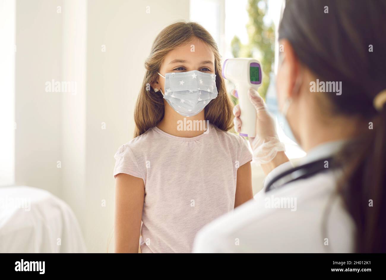 Nurse or doctor using an infrared thermometer to measure body