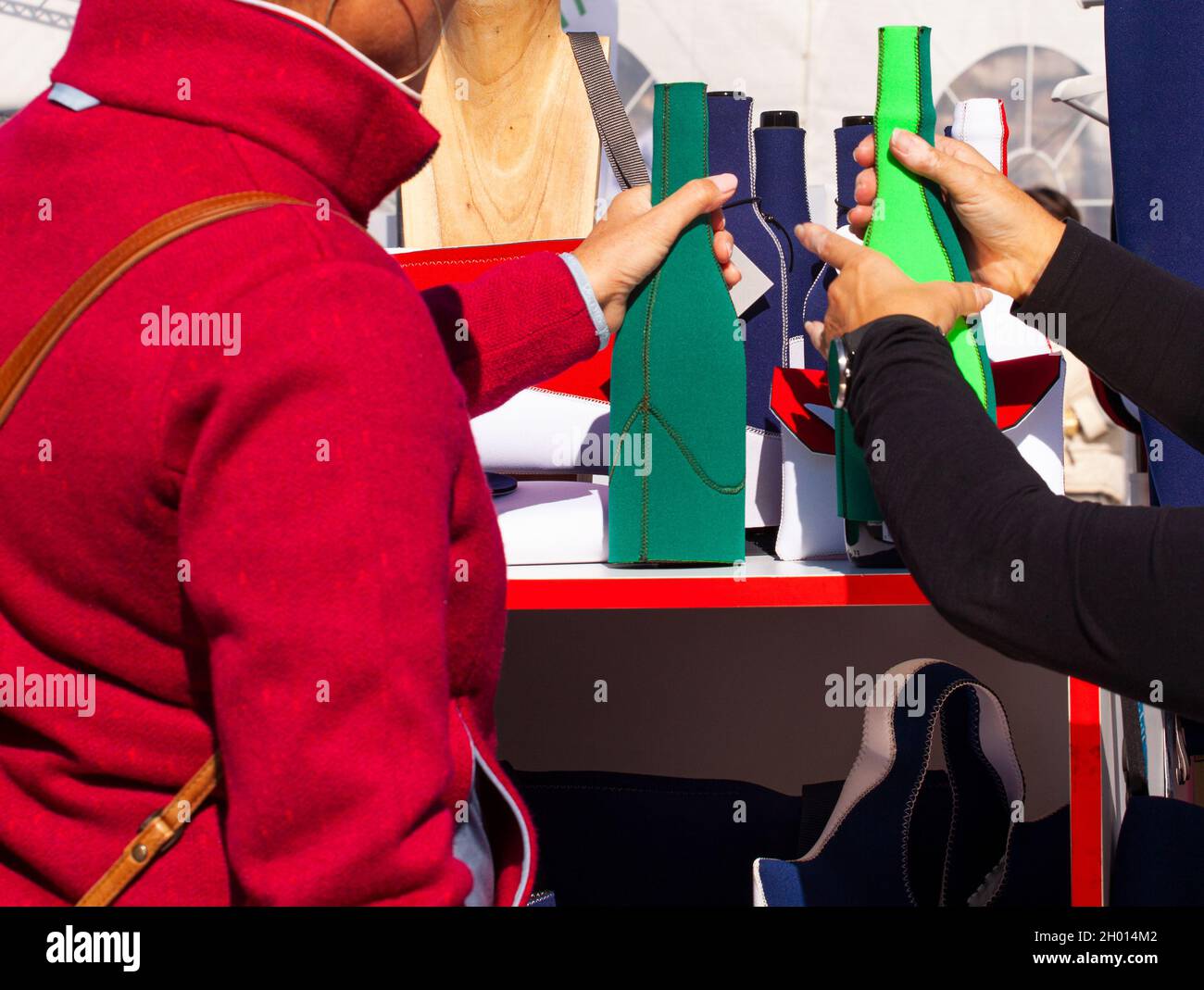 Woman with a red jacket buying a neoprene bottle in a specialized shop Stock Photo