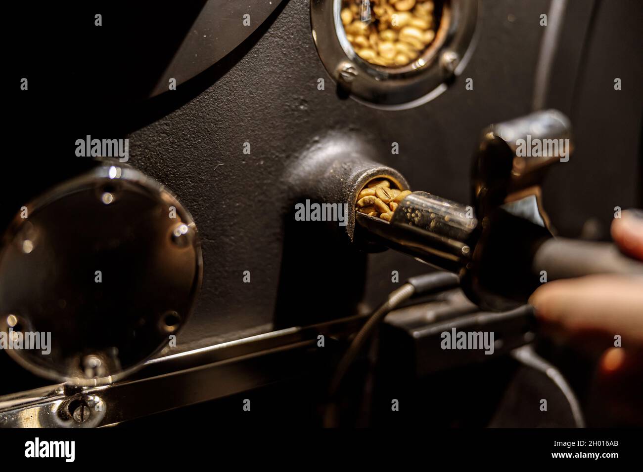 Male worker using industrial coffee roasting machine Stock Photo