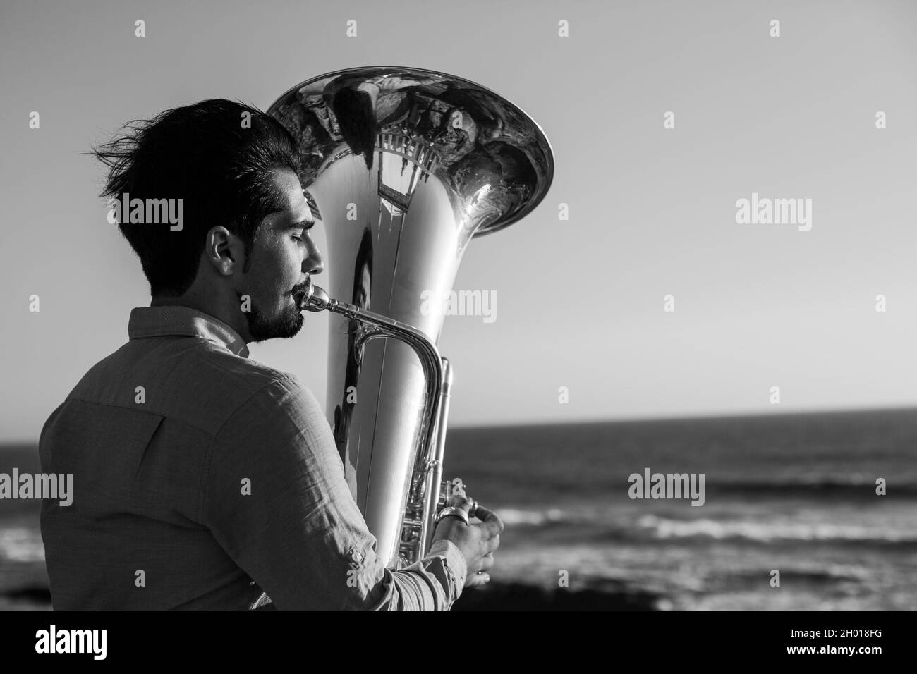 A musician man with a tuba on the Miramar beach, Portugal. Black and white photo. Stock Photo