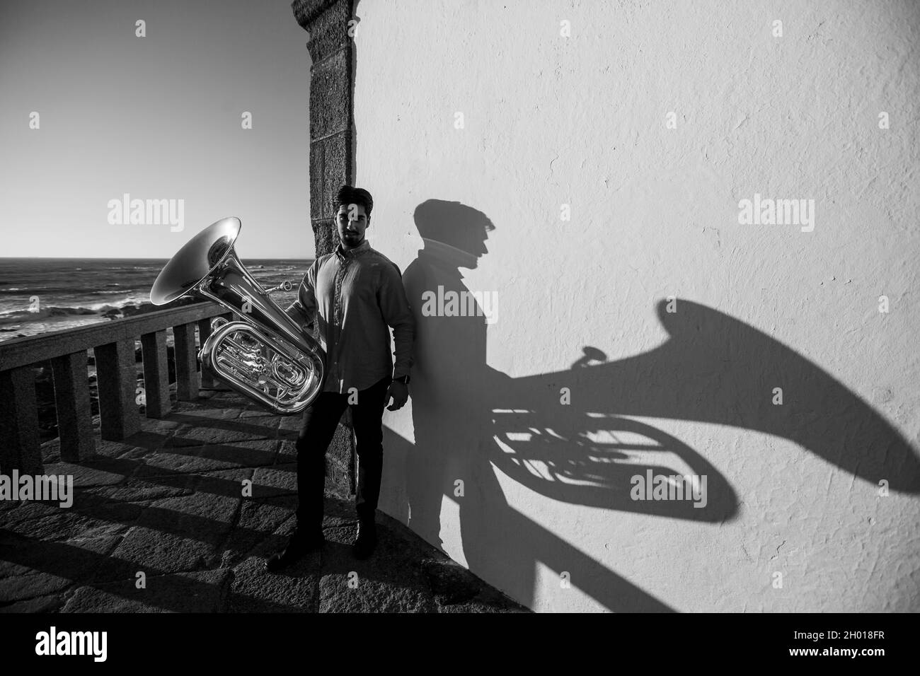 A musician man with a tuba on the Miramar beach, Porto, Portugal. Black and white photo. Stock Photo