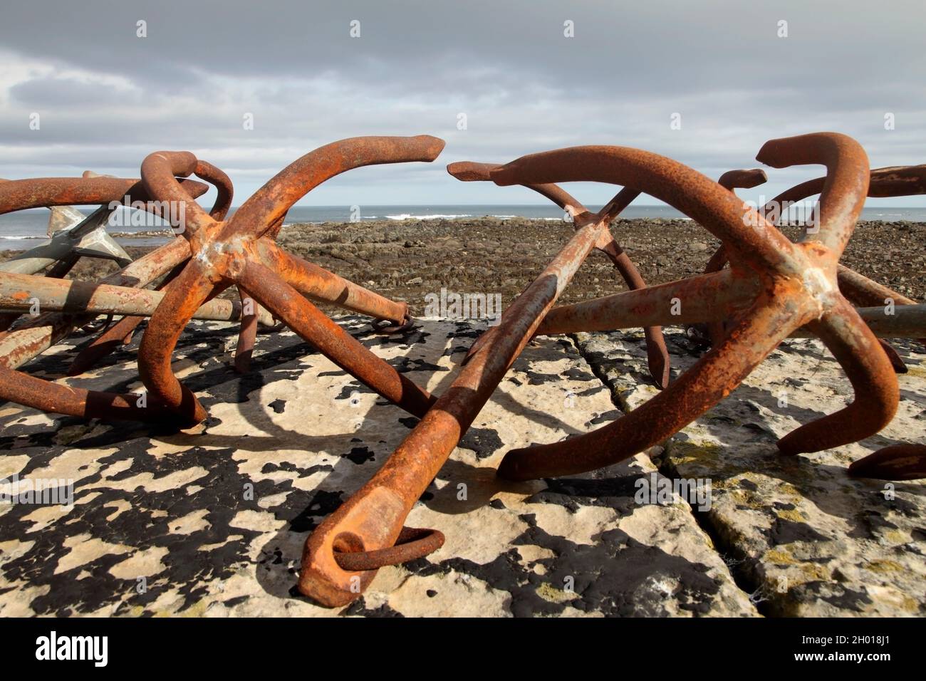 Marine anchors on stop of sea wall, Burnmouth, Berwickshire, Scotland, UK. Stock Photo