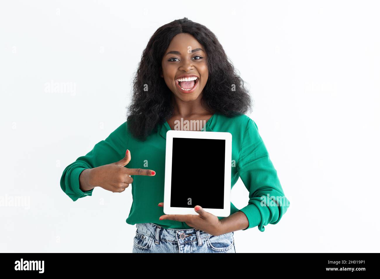 Emotional young black woman pointing at digital tablet with empty ...