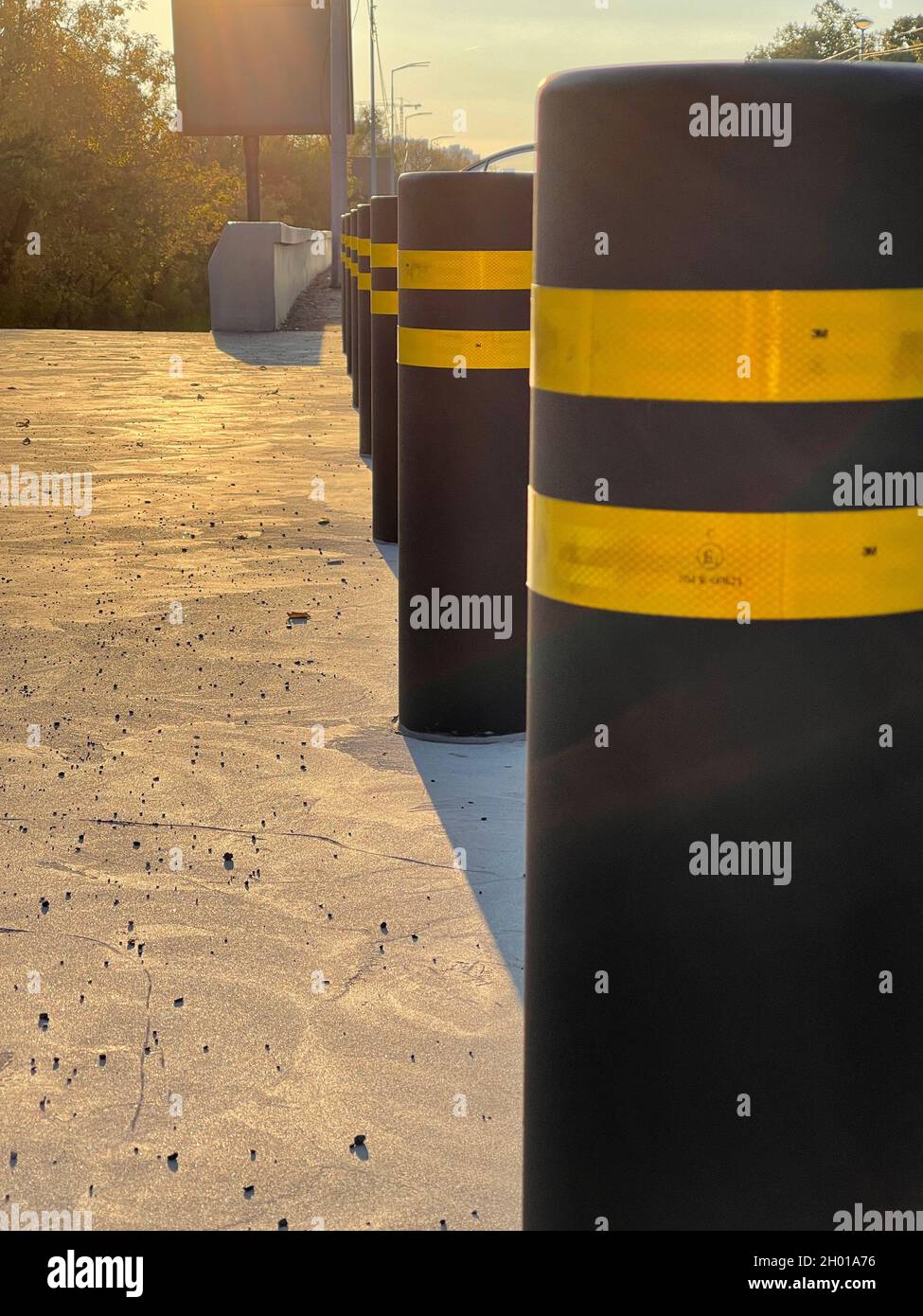 Row of anti parking bollards on the sidewalk on sunset Stock Photo