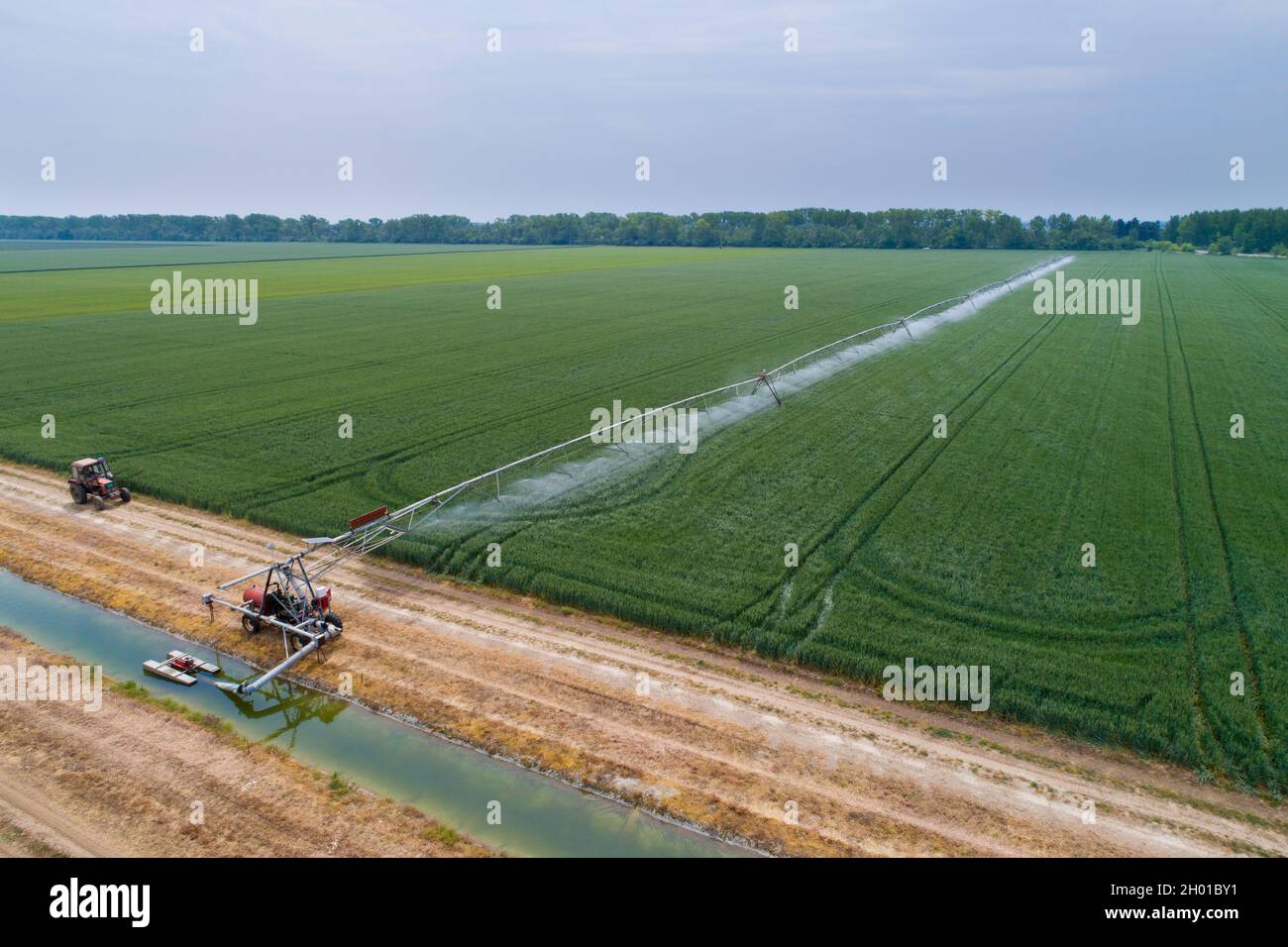 Aerial image of irrigation system in wheat field beside water channel