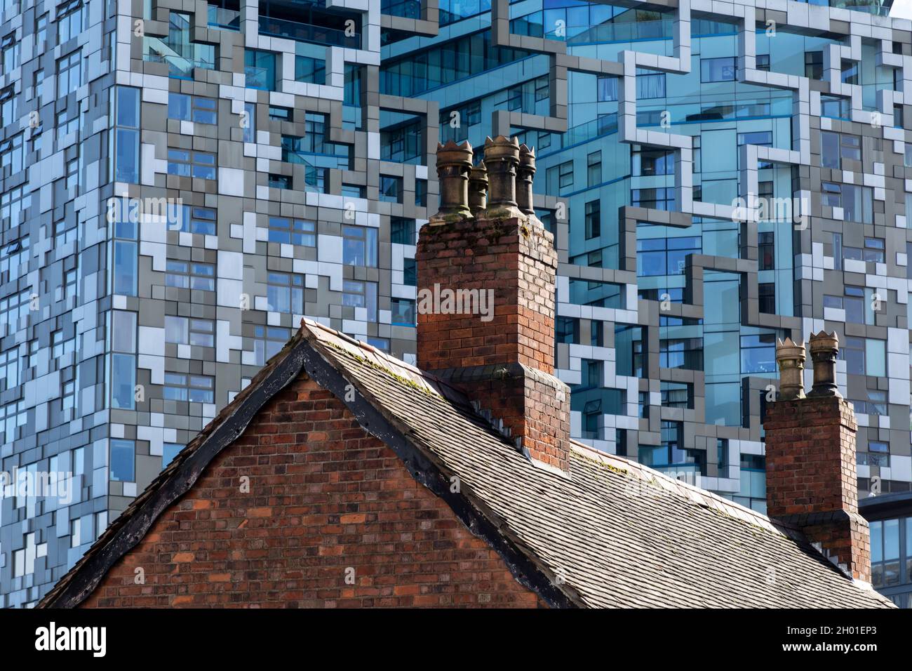 An old fashioned brick cottage in front of the modern Cube building in the centre of Birmingham, UK. Stock Photo