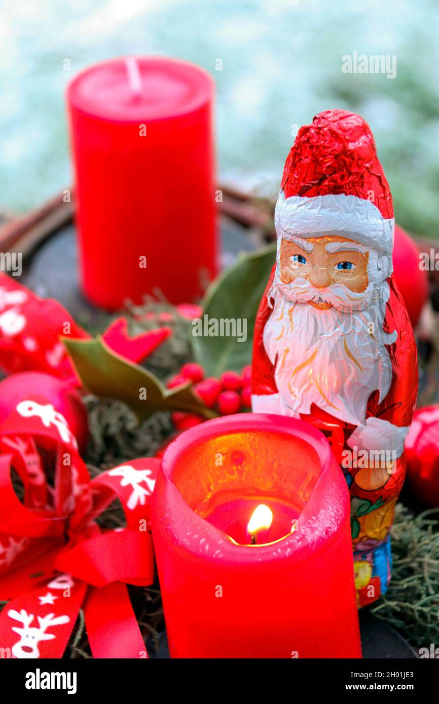 chocolate santa claus at christmas next to candles for christmas decoration Santa Claus Stock Photo