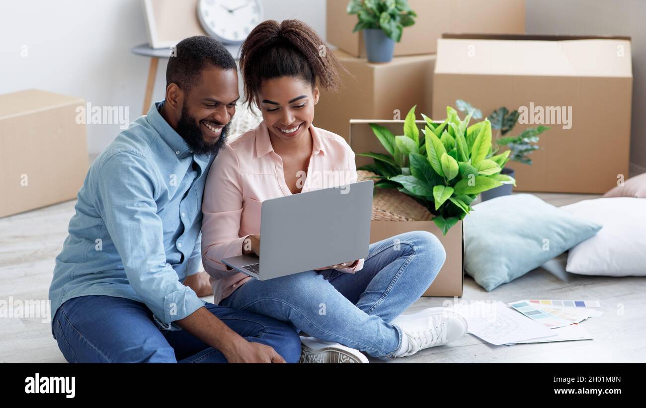 Smiling millennial african american wife showing to husband laptop with ...