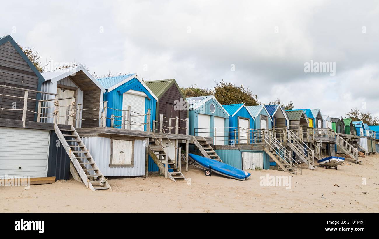 Abersoch beach huts lined up at the back of beach on the North Wales coast pictured in October 2021. Stock Photo