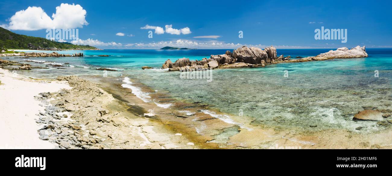 Old coral reef in the white sand beach on secluded beach of grand anse, La Digue, Seychelles. Aerial view Stock Photo