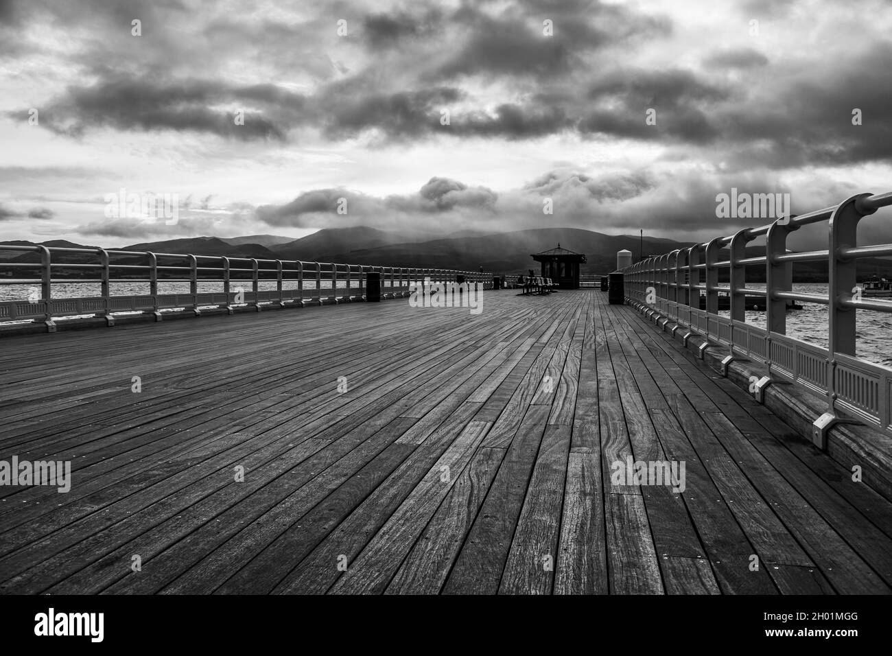 Beaumaris Pier in monochrome seen under a moody sky in October 2021 on the North Wales coast. Stock Photo