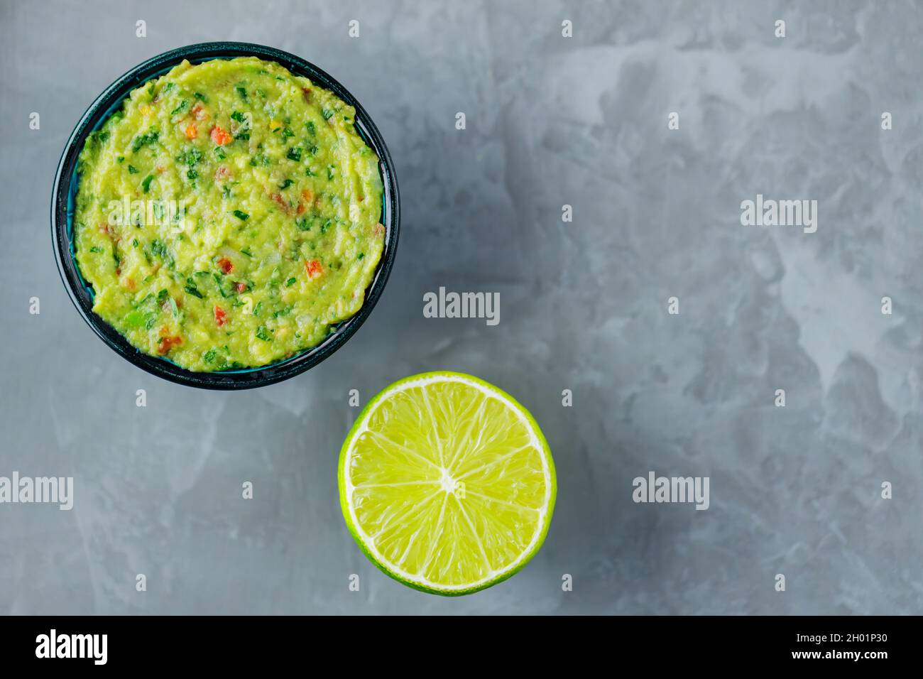 Guacamole bowl on a gray background. Traditional mexican dip sauce guacamole in the bowl. Mexican cuisine. Copy space. Top view Stock Photo