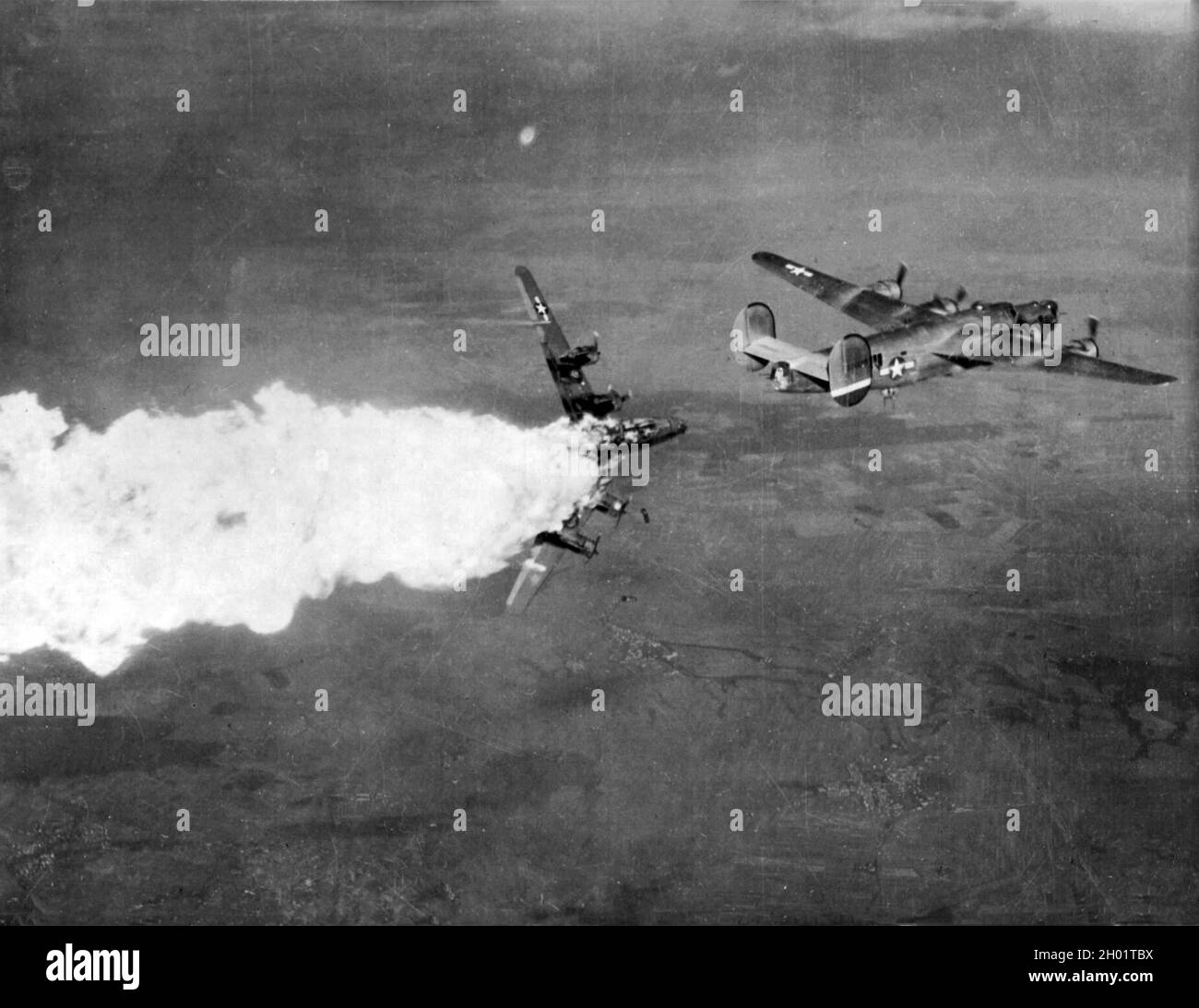 A Consolidated B-24 Liberator  bomber explodes in flames during a raid on a chemical complex in the town of Blechhammer. Stock Photo