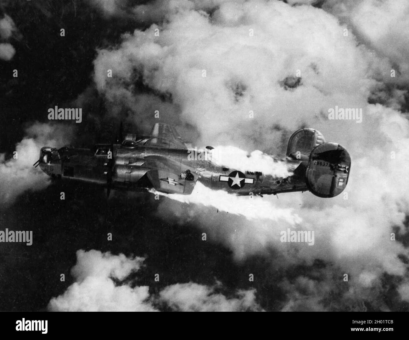 A Consolidated B-24 Liberator  bomber burning after being hit by flak during a raid. Stock Photo
