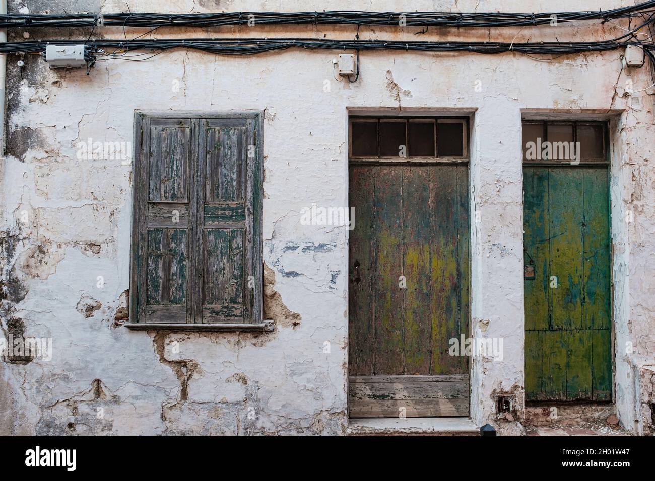 Abandoned building home facade with damaged wall and closed wooden ...