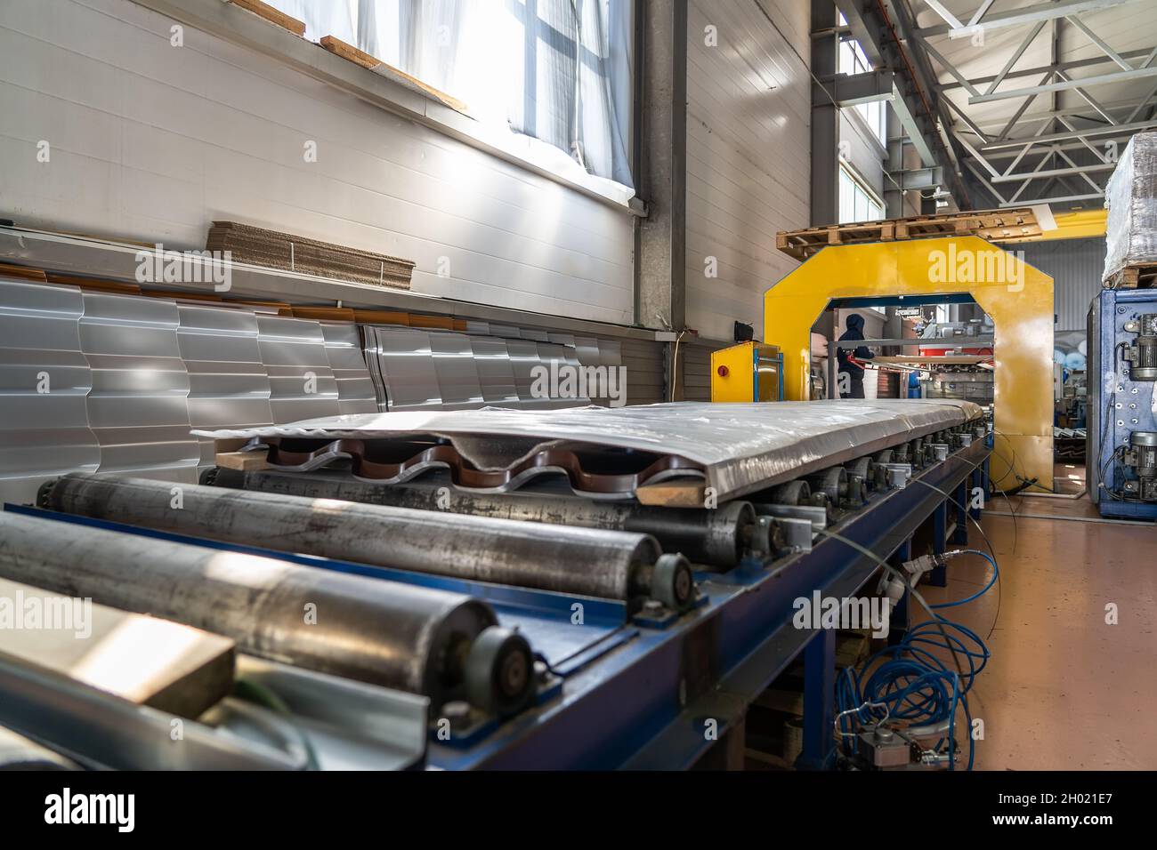 Conveyor with finished packaged products of metal tile sheets for roof
