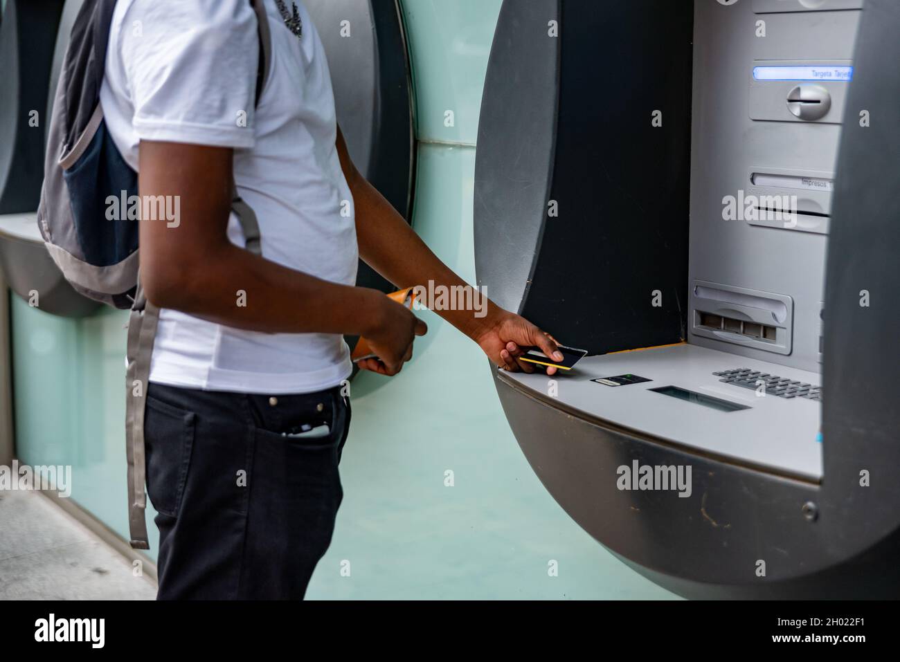 Unrecognizable afro man in ATM. Stock Photo