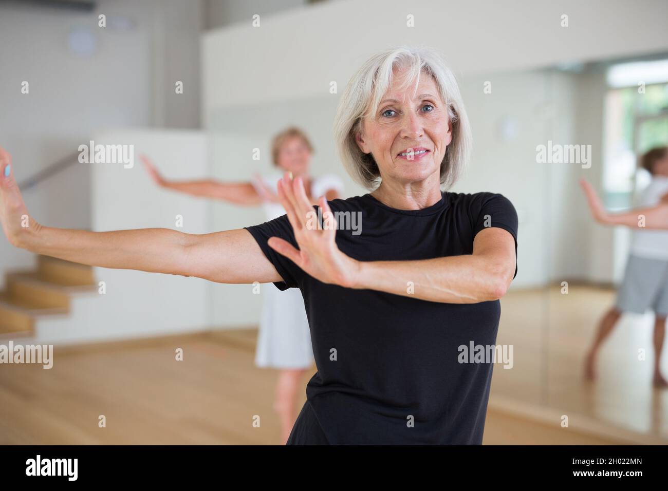 Active mature woman learning dynamic dances in choreography class Stock Photo
