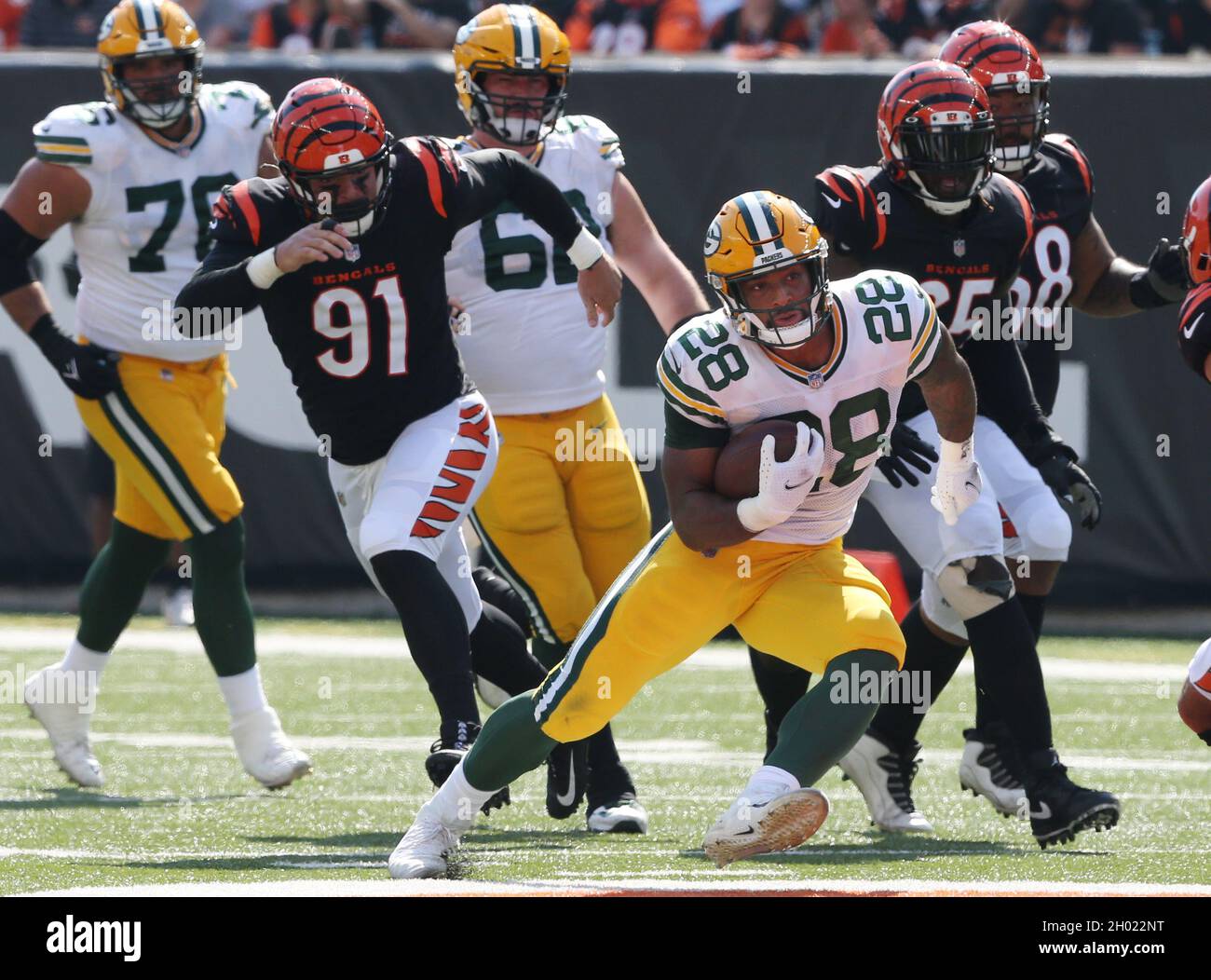 Cincinnati, United States. 10th Oct, 2021. Green Bay Packers running back AJ Dillion (28) breaks free from Cincinnati Bengals Trey Hendrickson (91) during the first half of play at Paul Brown Stadium in Cincinnati, Ohio, Sunday, October 10, 2021. Photo by John Sommers II /UPI Credit: UPI/Alamy Live News Stock Photo