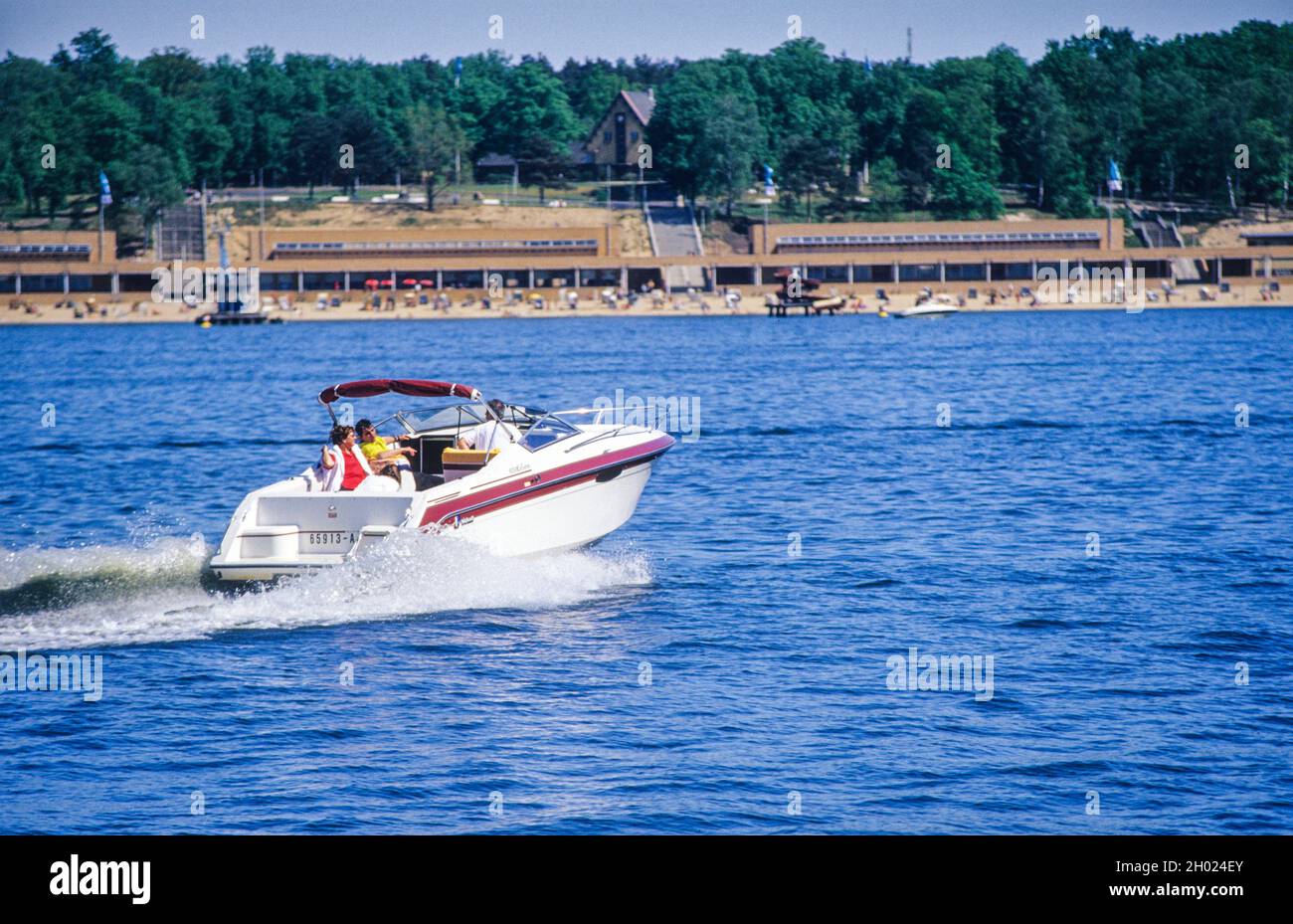 Summer in Berlin: motor-boat in front of the listed buildings of Wannsee public bathing beach. Stock Photo