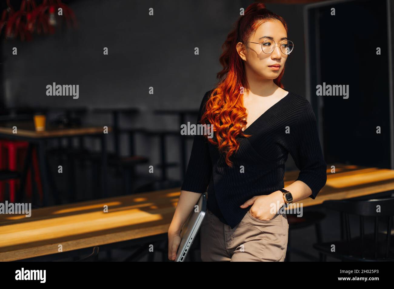 Image of happy business asian woman wearing glasses holding laptop ...