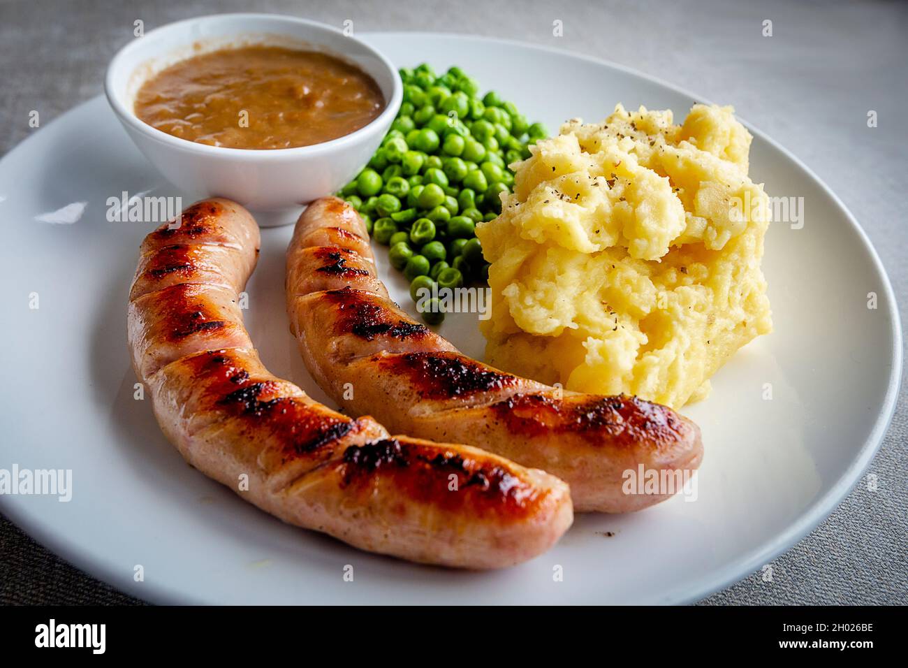 bangers and mash with peas and gravy Stock Photo Alamy