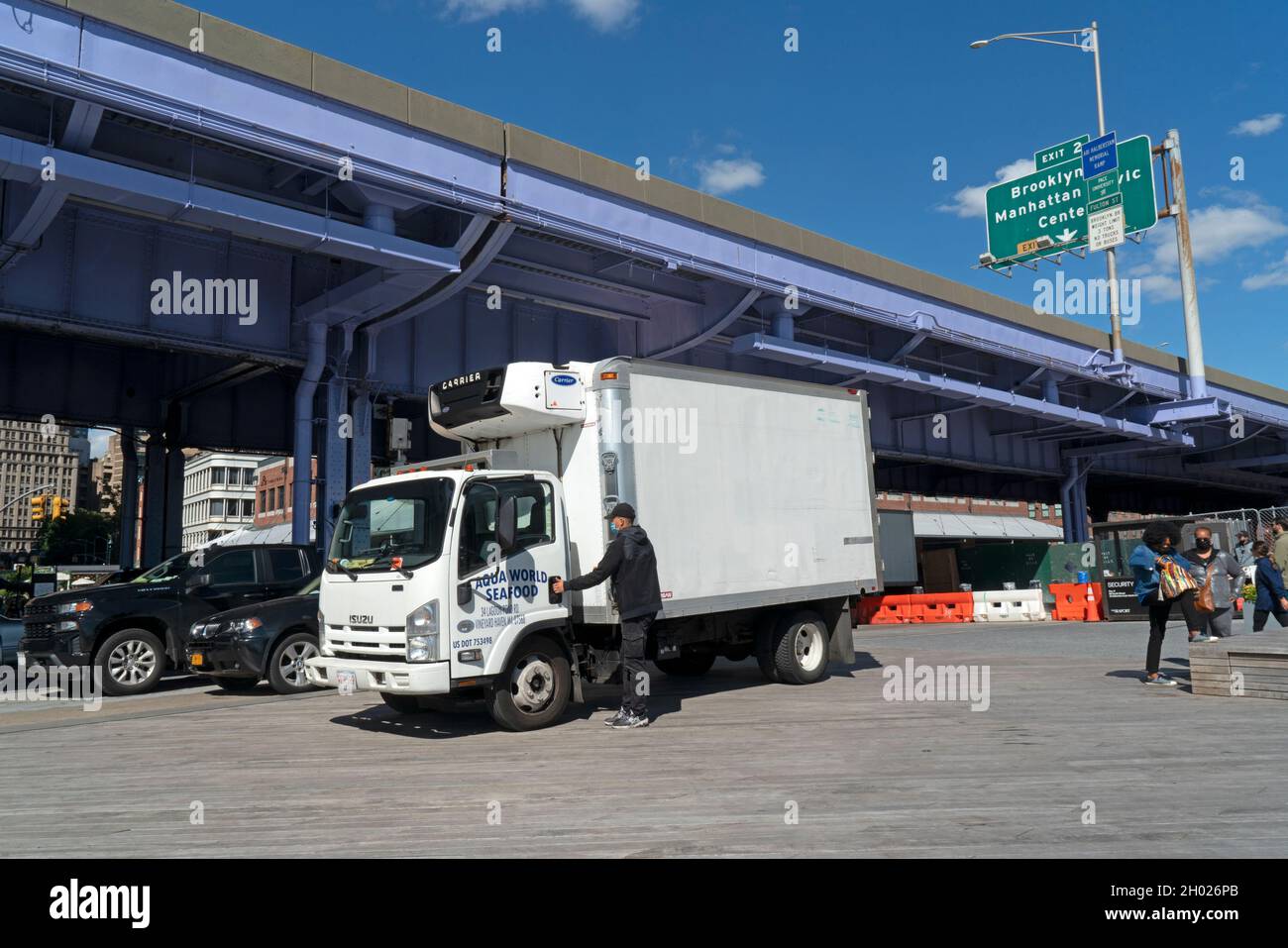 Next to the FDR Drive a truck makes a delivery of fish to Pier 16 in the South Street Seaport, which was once a central part of the Fulton Fish Market Stock Photo