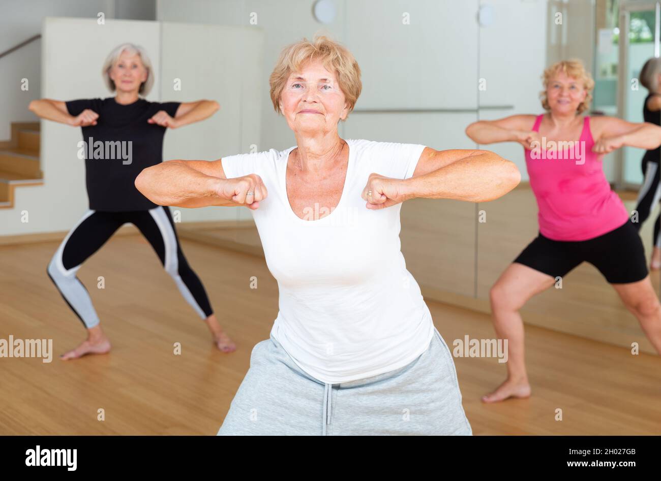 Energetic elderly woman practicing vigorous dance movements Stock Photo