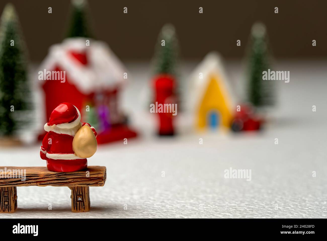 Santa Claus carrying a bag sitting on a bench. Stock Photo