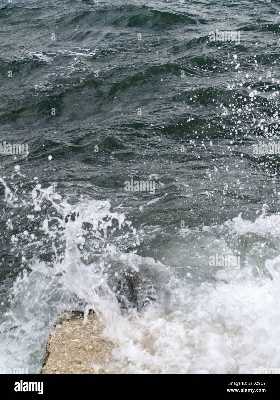 Waves crashing over rocks at Anemomylos, Garitsa Bay, Corfu, Greece Stock Photo