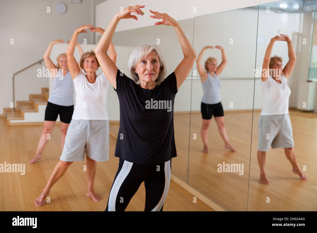 Mature woman learning classical ballet technique in choreography class Stock Photo