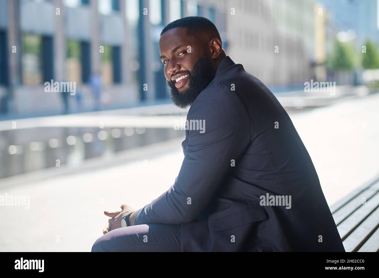 An african american man in an elegant suit sitting on the bench Stock ...