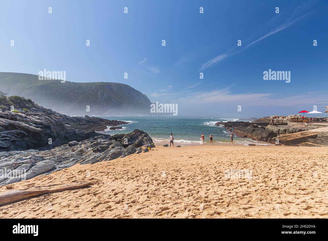 The view of fine sandy beach with rock outcrops and misty sea at Storms River Mouth in Tsitsikamma National Park off the Garden Route, South Africa. Stock Photo