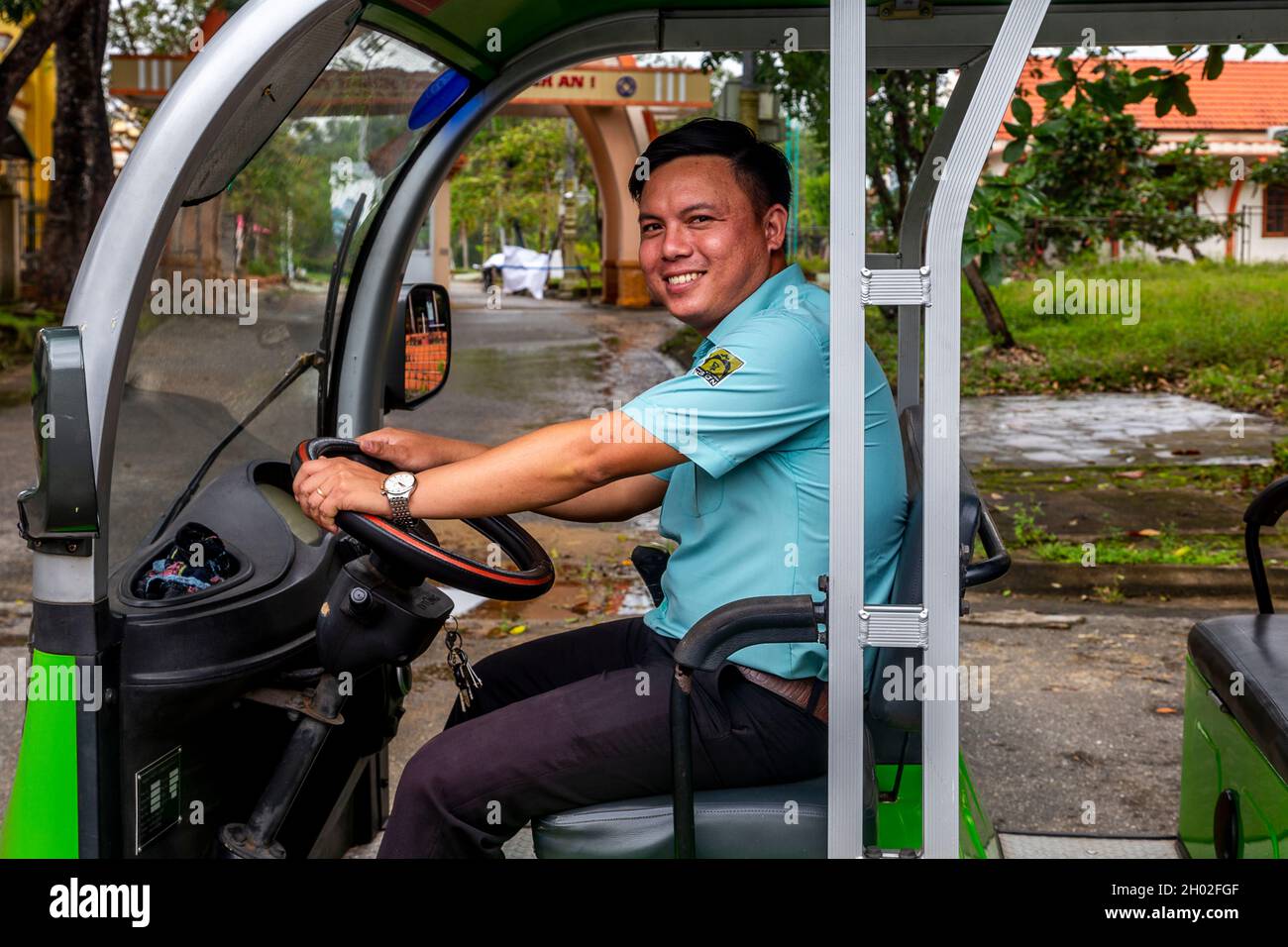 Shuttle bus operator smiles for the camera seated in the drivers seat
