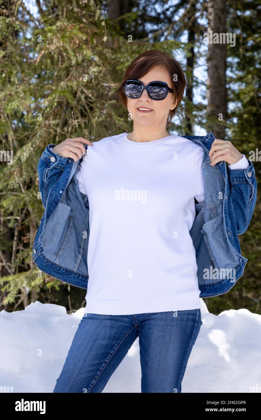 White fleece crewneck sweatshirt mockup featuring a woman wearing denim jacket. Heavyweight sweatshirt template, model mockup Stock Photo