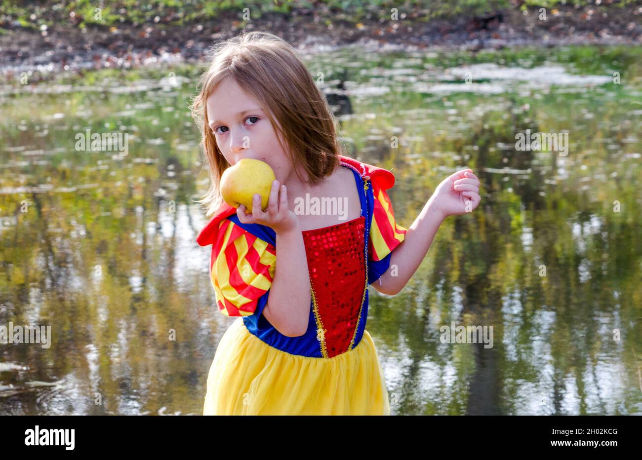 A young girl enjoys a fresh apple, as she plays dress up in her princess  Halloween costume. hope this is not a poison apple! Stock Photo - Alamy