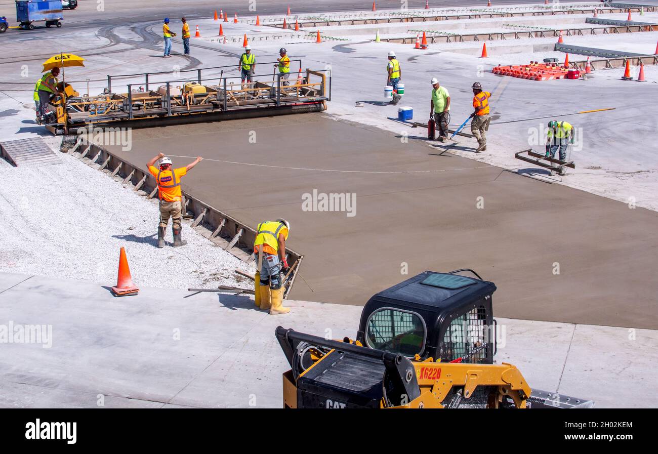 Midway airport Chicago IL USA; June 3, 2021; a crew works on a section of fresh cement outside a busy airport Stock Photo