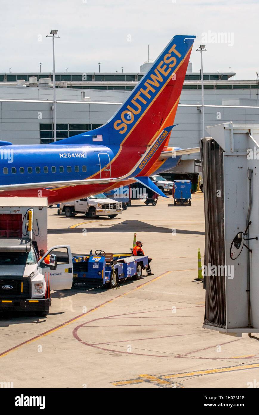 Denver airport Colorado USA; June 3, 2021 A baggage handler waits for