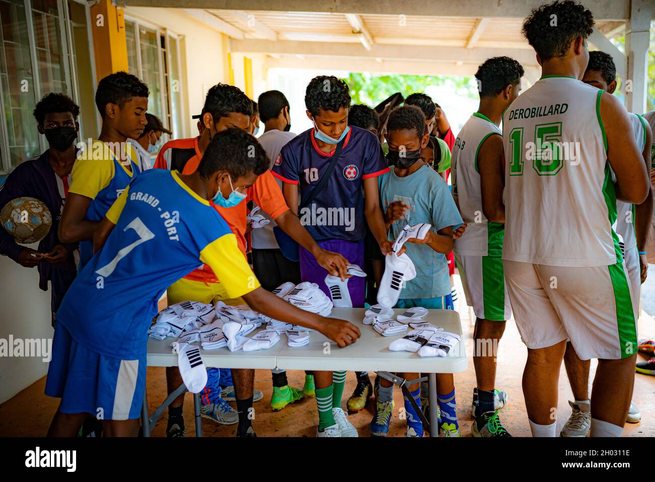 Young sporting hopefuls collect brand new sports socks and other sporting equipment, donated by the United Through Sport charity in between coaching sessions at a training hub in Mauritius, where youngsters are given free sports training and coaching on the island to help them pursue a career in professional sport. Picture date: Sunday October 10, 2021. Stock Photo