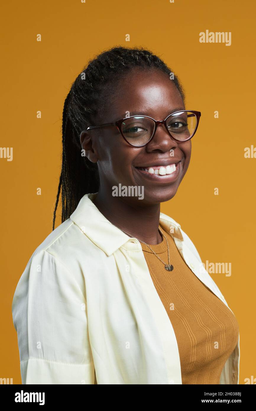 Vertical portrait of young African-American woman wearing glasses and ...
