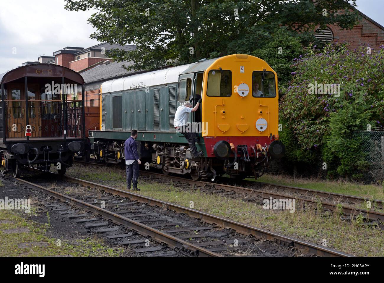 A train driver climbs into the cab of an ex British Railways Class 20 'Chopper' diesel loco at the Great Central Railway, Loughborough, August 2021 Stock Photo