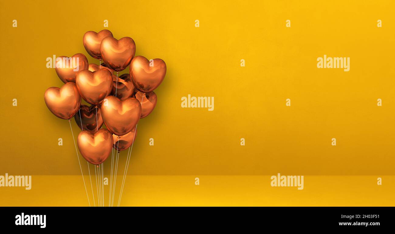 Copper heart shape balloons bunch on a yellow wall background ...
