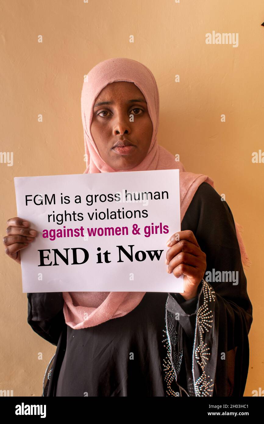 An African Muslim woman holding up sign saying End FGM Stock Photo