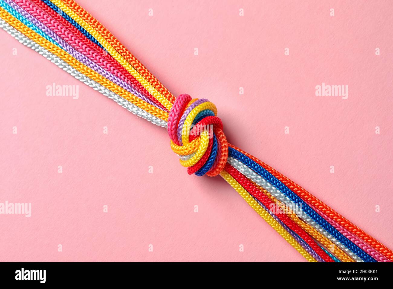 Different ropes tied together with knot on color background. Unity ...